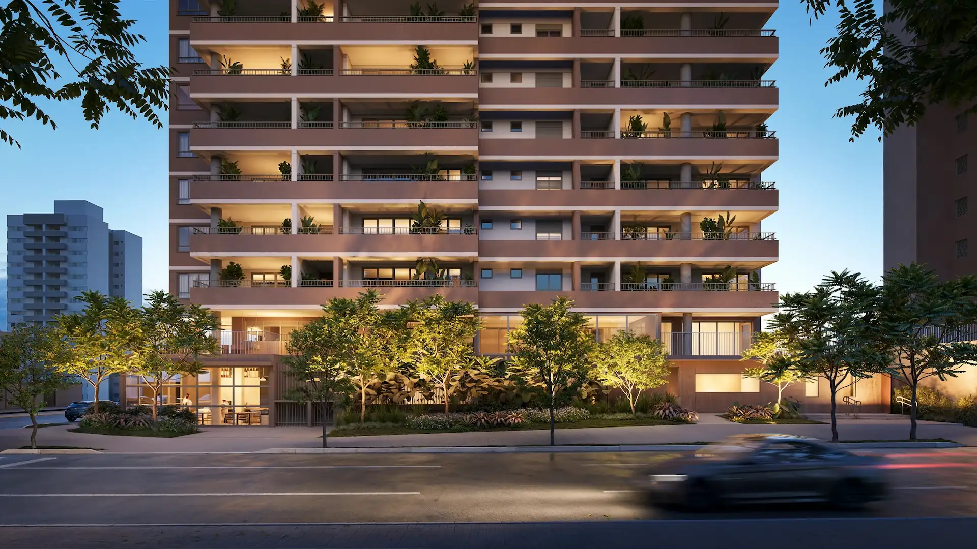 Fachada iluminada do Eucalys, apartamento em Moema, com varandas ajardinadas, iluminação suave e vegetação ao redor.