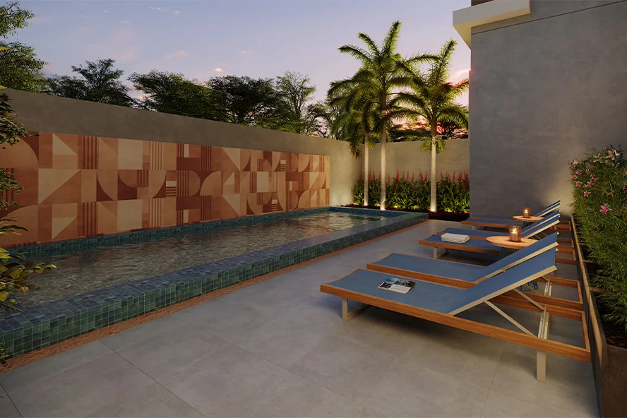 Piscina externa do Eucalys, apartamento em Moema, com espreguiçadeiras e paisagismo ao entardecer.