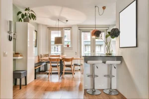 Cozinha integrada e sala de jantar luminosa em apartamento compacto moderno.