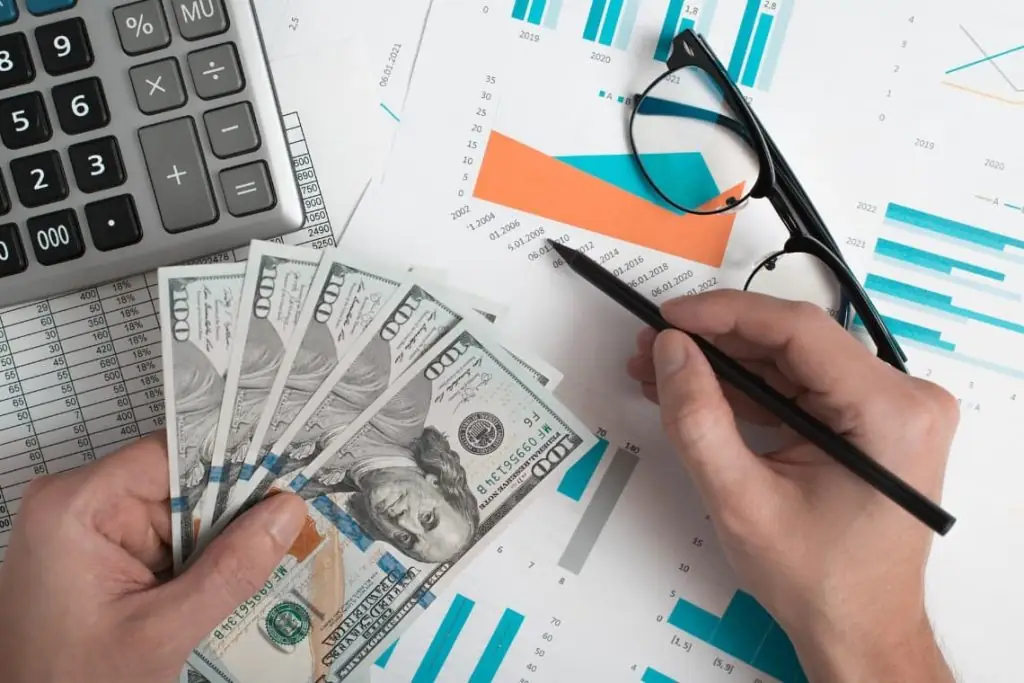 dinheiro ao lado de um óculos e lápis